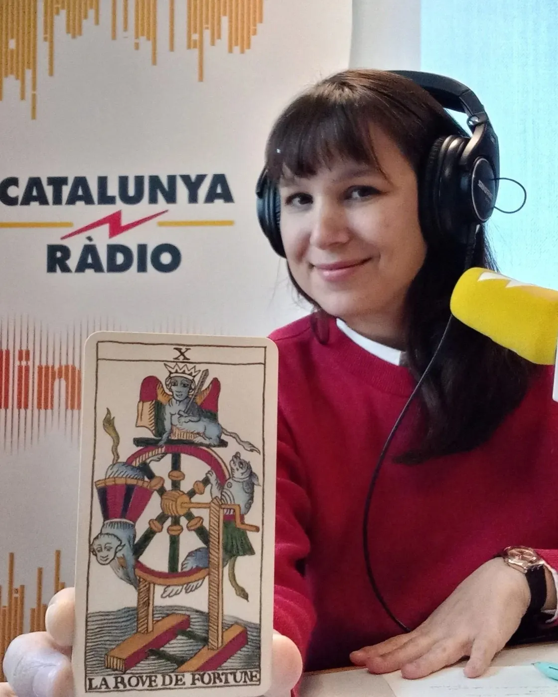 La Clara a l'estudi de Catalunya Ràdio, amb auriculars i la carta de la Roda de la Fortuna
